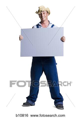 Farmer wearing a straw hat holding a blank sign View Large Photo Image Stock Photograph - Farmer wearing a straw hat holding a blank sign. Fotosearch