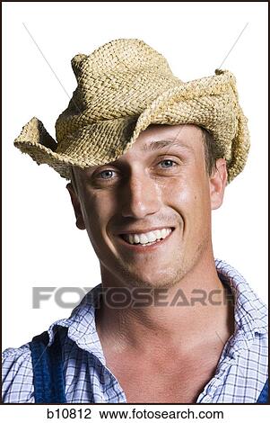 Stock Image - Farmer wearing a straw hat smiling. Fotosearch