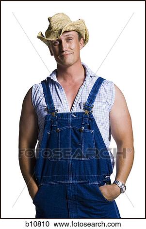 Stock Image - Farmer wearing a straw hat with hands in pockets. Fotosearch