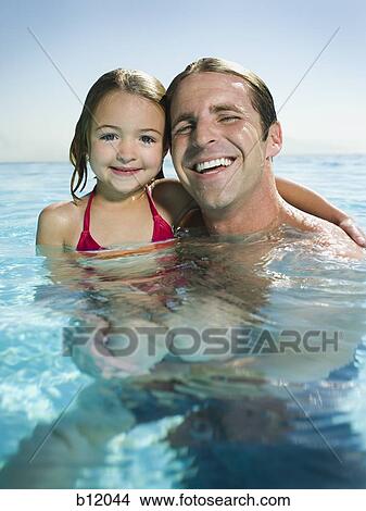 Picture - Father and daughter in infinity pool. Fotosearch