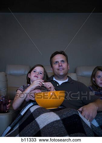 Father and daughters watching movie in home theater View Large Photo Image Stock Image - Father and daughters watching movie in home theater. Fotosearch