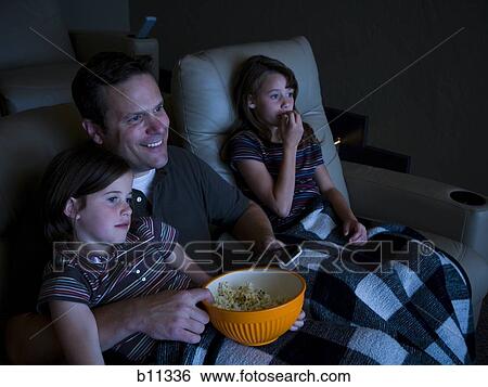 Father and daughters watching movie in home theater View Large Photo Image Stock Photograph - Father and daughters watching movie in home theater. Fotosearch