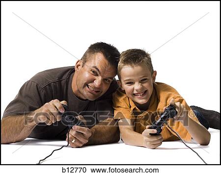 Father and son playing a video game View Large Photo Image Stock Image - Father and son playing a video game. Fotosearch