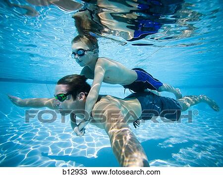 Father and son swimming underwater in pool View Large Photo Image Stock Image - Father and son swimming underwater in pool. Fotosearch