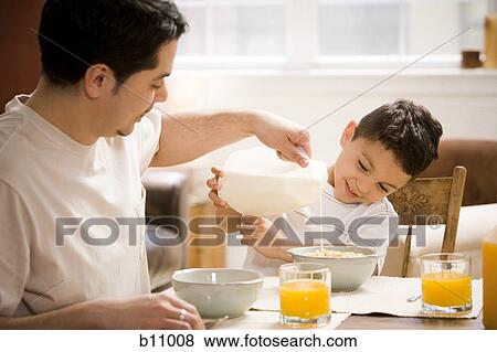 Father and young son having breakfast together View Large Photo Image Stock Photo - Father and young son having breakfast together. Fotosearch