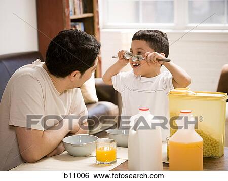 Father and young son having breakfast together View Large Photo Image Stock Photograph - Father and young son having breakfast together. Fotosearch