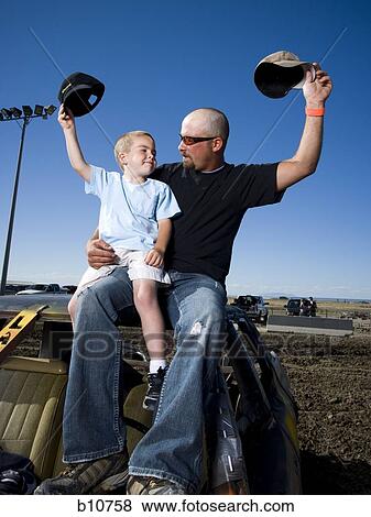Father and young son waving ball caps in air View Large Photo Image Stock Photo - Father and young son waving ball caps in air. Fotosearch
