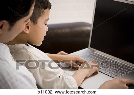 Father and young son working on laptop computer View Large Photo Image Stock Image - Father and young son working on laptop computer. Fotosearch