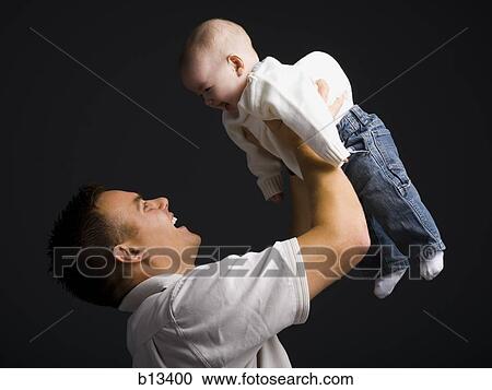 Stock Image - Father holding baby boy. Fotosearch