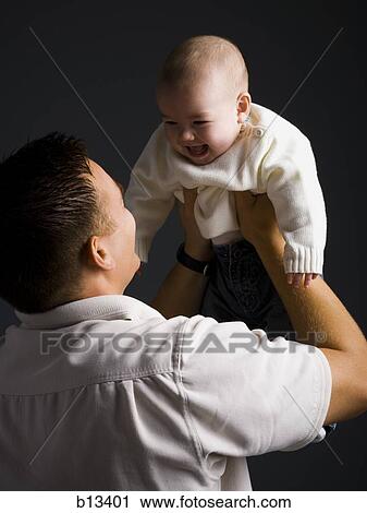Stock Image - Father holding baby boy. Fotosearch