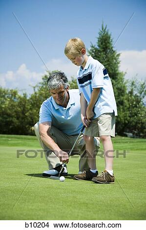 Picture - Father teaching his son to play golf. Fotosearch