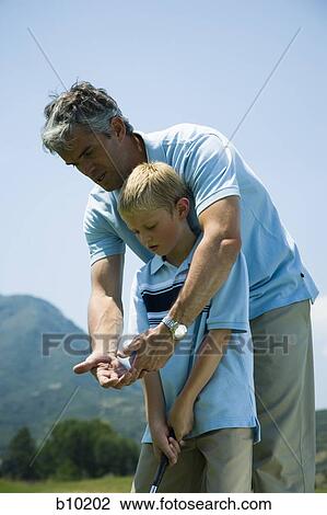 Father teaching his son to play golf View Large Photo Image Stock Image - Father teaching his son to play golf. Fotosearch