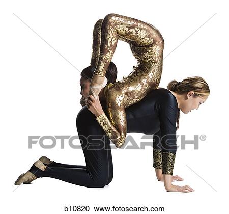 Stock Image - Female contortionist duo performing. Fotosearch