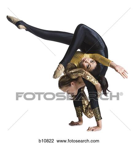 Stock Image - Female contortionist duo performing. Fotosearch