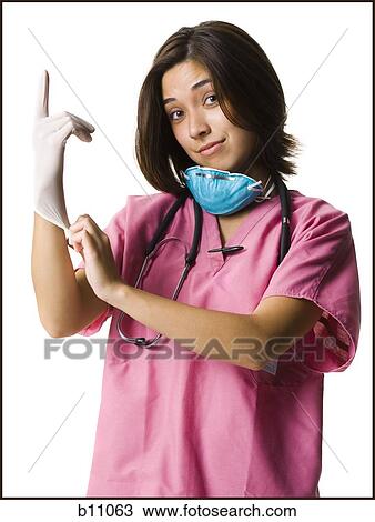 Female doctor in pink scrubs with rubber glove View Large Photo Image Stock Image - Female doctor in pink scrubs with rubber glove. Fotosearch