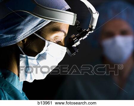 Female doctor in scrubs with head light in surgery View Large Photo Image Stock Image - Female doctor in scrubs with head light in surgery. Fotosearch