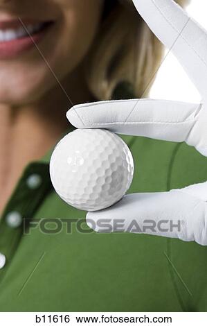 Stock Photograph - Female golfer and close-up of golf ball. Fotosearch