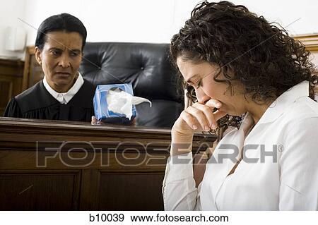 Stock Photo - Female judge offering tissue to a female witness. Fotosearch