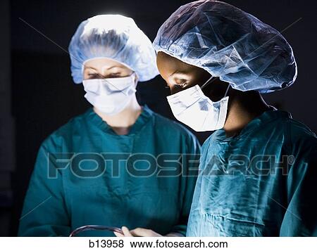 Female nurse and surgeon in scrubs during surgery View Large Photo Image Stock Photo - Female nurse and surgeon in scrubs during surgery. Fotosearch