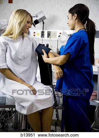 Female patient with blood pressure cuff during examination with nurse View Large Photo Image Stock Image - Female patient with blood pressure cuff during examination with nurse. Fotosearch