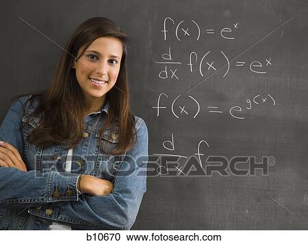 Stock Image - Female student leaning against chalkboard. Fotosearch