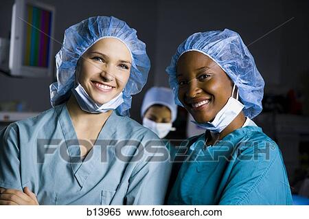 Stock Photography - Female surgeon and nurse in scrubs smiling. Fotosearch