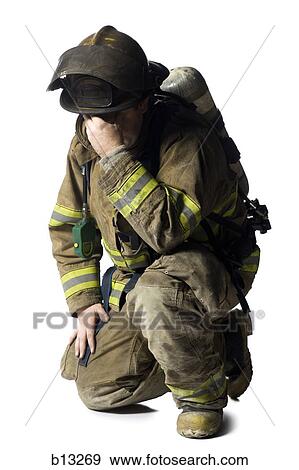 Firefighter crouching and sad View Large Photo Image Stock Photo - Firefighter crouching and sad. Fotosearch