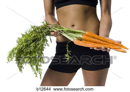 Fit woman holding carrots View Large Photo Image Picture - Fit woman holding carrots. Fotosearch