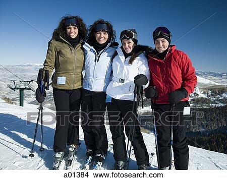 Picture - Four women standing outdoors in winter with skis. Fotosearch