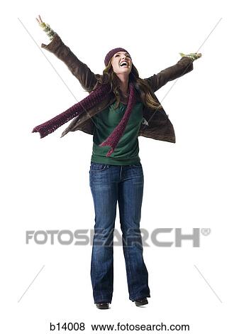 Stock Photo - Full length woman with arms raised wearing toque smiling. Fotosearch