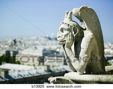 Stock Image - Gargoyle atop building. Fotosearch