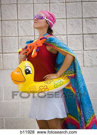Stock Photo - Girl at swimming pool with life ring and water pistol. Fotosearch