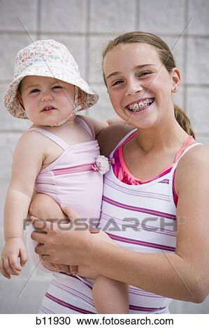 Stock Image - Girl holding baby. Fotosearch