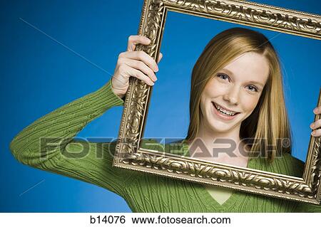 Girl looking through picture frame smiling View Large Photo Image Stock Photograph - Girl looking through picture frame smiling. Fotosearch