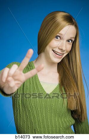 Girl making peace sign smiling View Large Photo Image Stock Image - Girl making peace sign smiling. Fotosearch