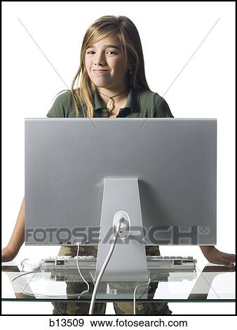 Stock Photo - Girl standing behind computer monitor smiling. Fotosearch
