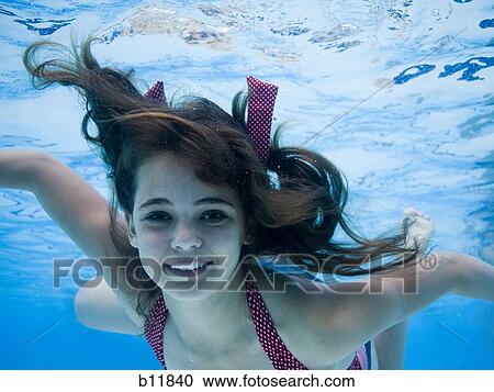 Girl swimming underwater in pool View Large Photo Image Stock Image - Girl swimming underwater in pool. Fotosearch