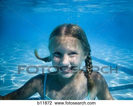 Girl swimming underwater in pool View Large Photo Image Stock Image - Girl swimming underwater in pool. Fotosearch