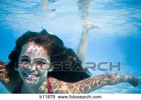Girl swimming underwater in pool View Large Photo Image Stock Photo - Girl swimming underwater in pool. Fotosearch