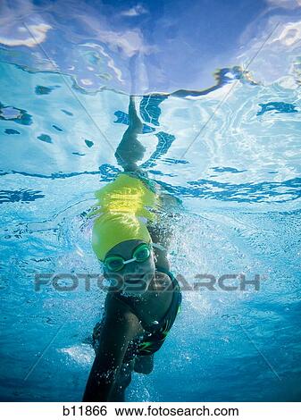 Girl swimming underwater in pool View Large Photo Image Stock Photograph - Girl swimming underwater in pool. Fotosearch