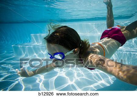 Stock Photograph - Girl swimming underwater in pool. Fotosearch