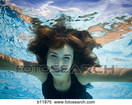 Girl swimming underwater in pool View Large Photo Image Stock Photography - Girl swimming underwater in pool. Fotosearch
