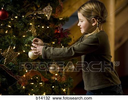 Girl with Christmas bauble and Christmas tree View Large Photo Image Stock Image - Girl with Christmas bauble and Christmas tree. Fotosearch