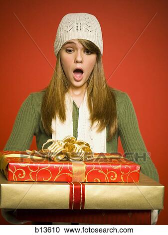 Girl with Christmas gifts pleasantly surprised View Large Photo Image Stock Image - Girl with Christmas gifts pleasantly surprised. Fotosearch