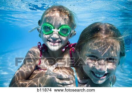 Picture - Girls swimming underwater in pool. Fotosearch