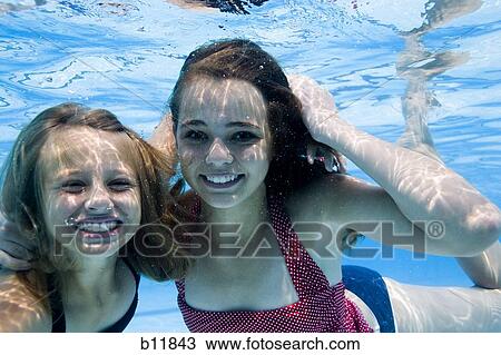Girls swimming underwater in pool View Large Photo Image Stock Image - Girls swimming underwater in pool. Fotosearch