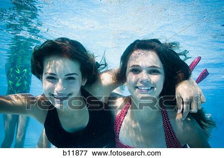 Girls swimming underwater in pool View Large Photo Image Stock Photo - Girls swimming underwater in pool. Fotosearch