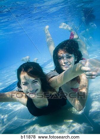 Girls swimming underwater in pool View Large Photo Image Stock Photo - Girls swimming underwater in pool. Fotosearch