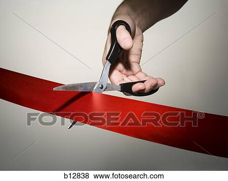 Stock Photo - Hand cutting a red ribbon with scissors. Fotosearch