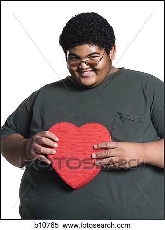 Stock Photography - Heavyset young man with valentine box. Fotosearch
